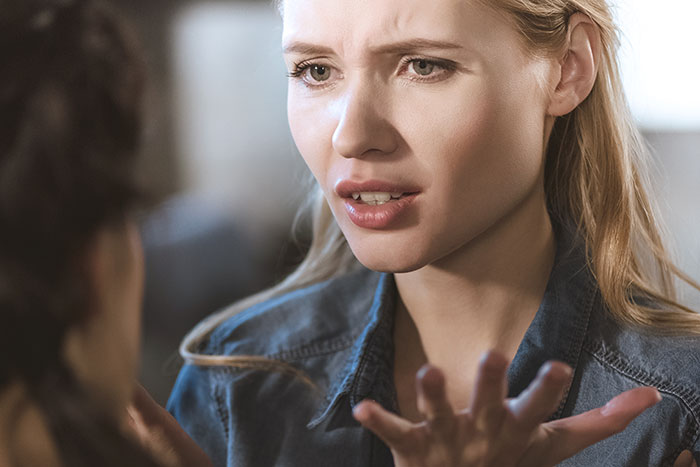 Young woman looking upset and regretful after blowing up at family during Thanksgiving dinner conversation. Young woman looking upset and regretful after blowing up at family during Thanksgiving dinner conversation.