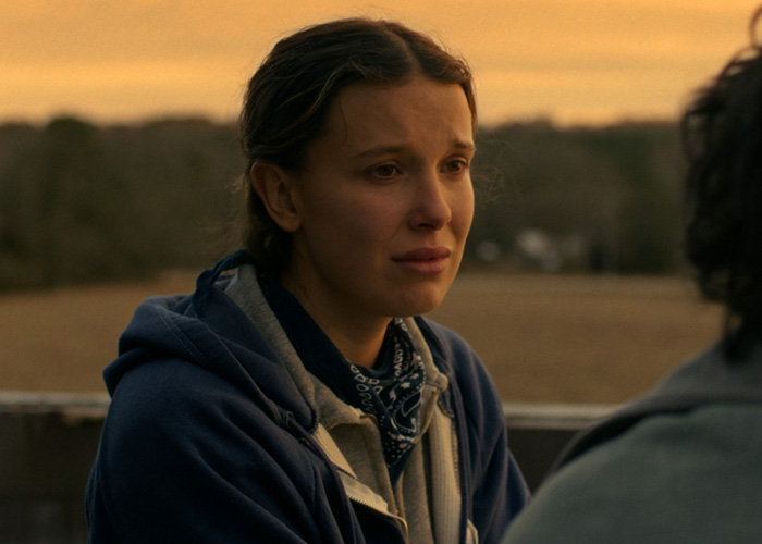 Millie Bobby Brown in a heartfelt scene from Stranger Things, captured during a golden hour outdoors conversation.