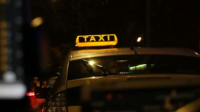 Nighttime scene of a taxi with its illuminated sign, capturing moments when people instinctively felt something was wrong.