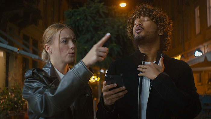 Girl upset and crying while roasting friend with insults during heated argument on city street at night