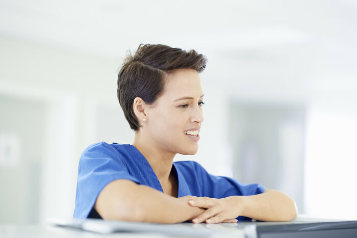 Medical staff in blue scrubs smiling while interacting, highlighting moments with patients coming off anesthesia humorously.