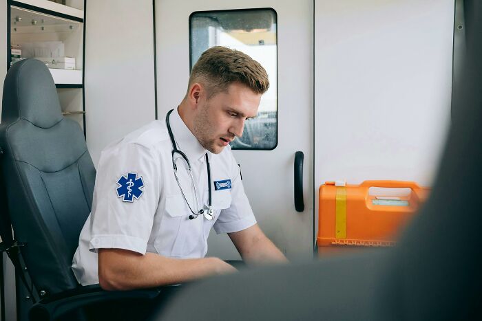 Medical staff inside ambulance, focused and attentive while caring for patients coming off anesthesia, showing concern and professionalism.