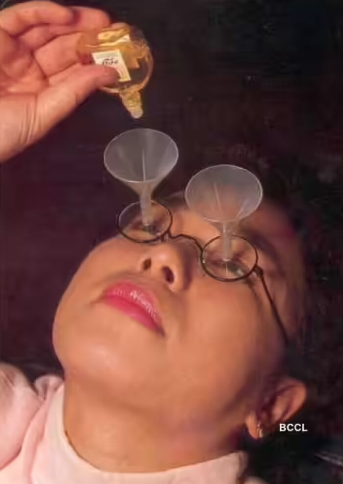 Person wearing glasses with tiny funnels over the eyes, humorously demonstrating pointless things with no practical purpose.