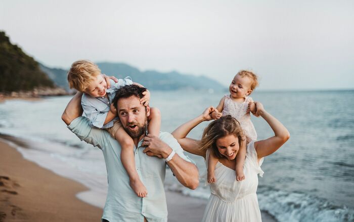 Happy family enjoying a beach day together, unaware of dark secrets that could change how people look at them.