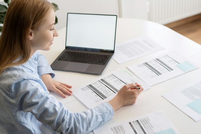 Woman reviewing documents and laptop, illustrating the moment people discover dark secrets and change their perspective.