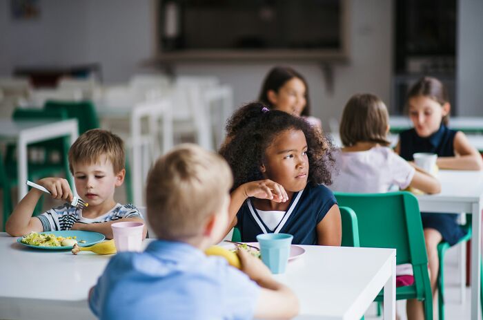 Group of children eating lunch at school cafeteria, illustrating bizarre and unusual names given to kids.