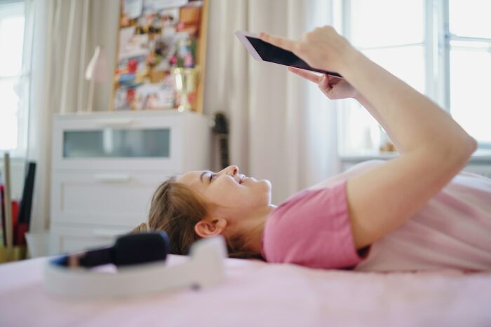Person lying on bed using a tablet, illustrating everyday things people accidentally did wrong for a long time.