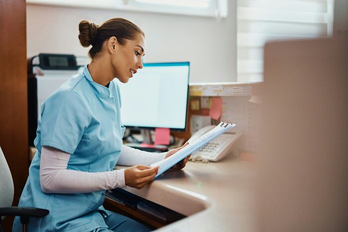 Healthcare professional seated at desk reviewing documents, illustrating small decisions that changed the course of lives.