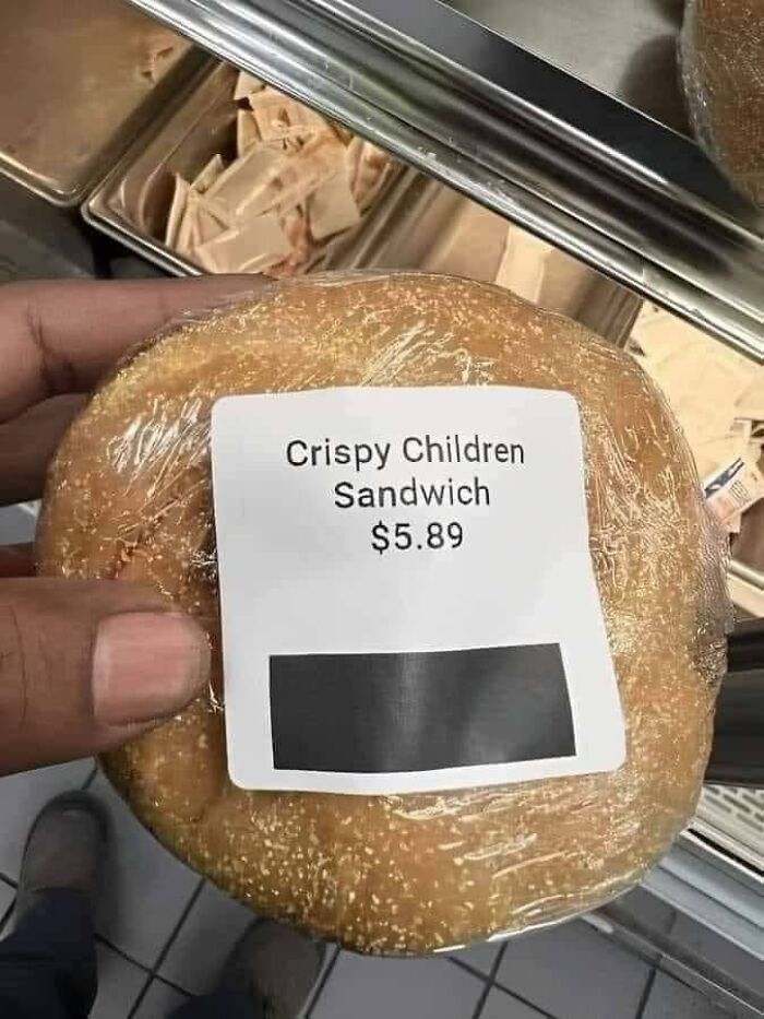 Hand holding a sandwich labeled crispy children sandwich priced at 5.89 in a kitchen setting funny memes.