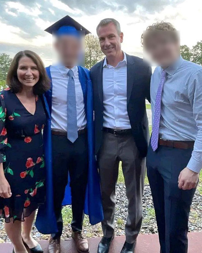 HR exec Kristin Cabot standing with three men at an outdoor event, dressed in a floral dress and smiling.
