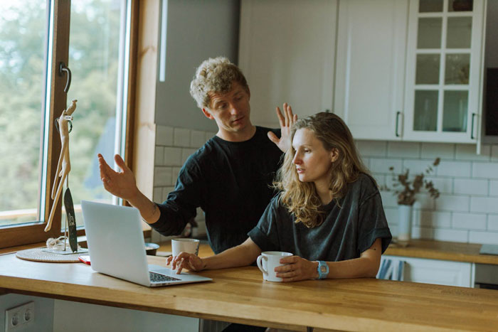 Man and woman in kitchen discussing open marriage, man appearing frustrated and unsure while woman listens quietly. Man and woman in kitchen discussing open marriage, man appearing frustrated and unsure while woman listens quietly.