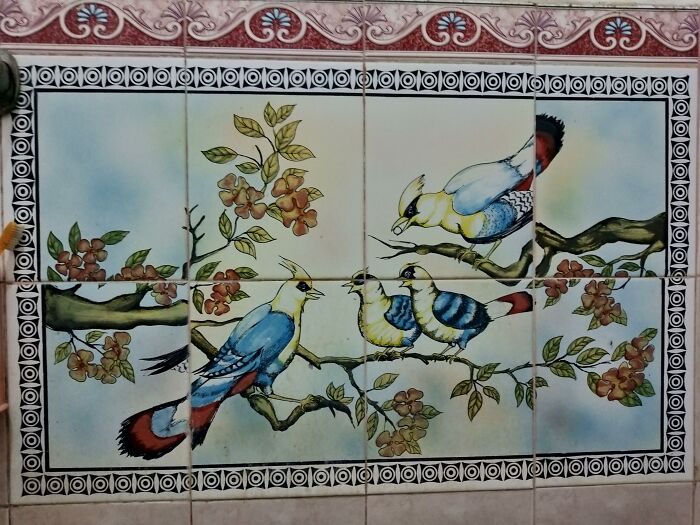 Ceramic tile artwork of birds on branches showing poor job e*******n with mismatched tile alignment.