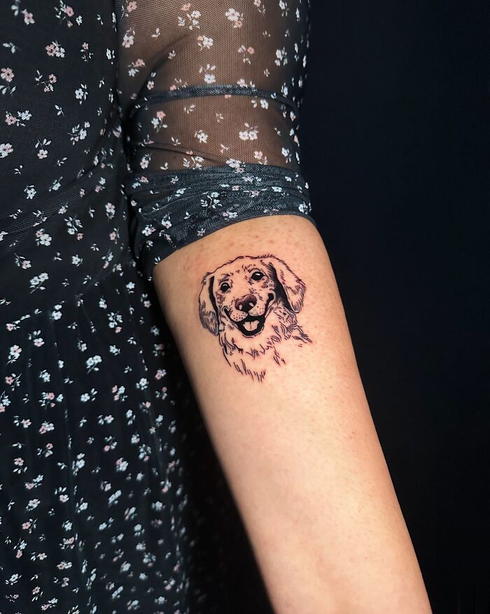 Tattoo of a happy dog's face on forearm, a beautiful tribute turning memories of people's pets into art.