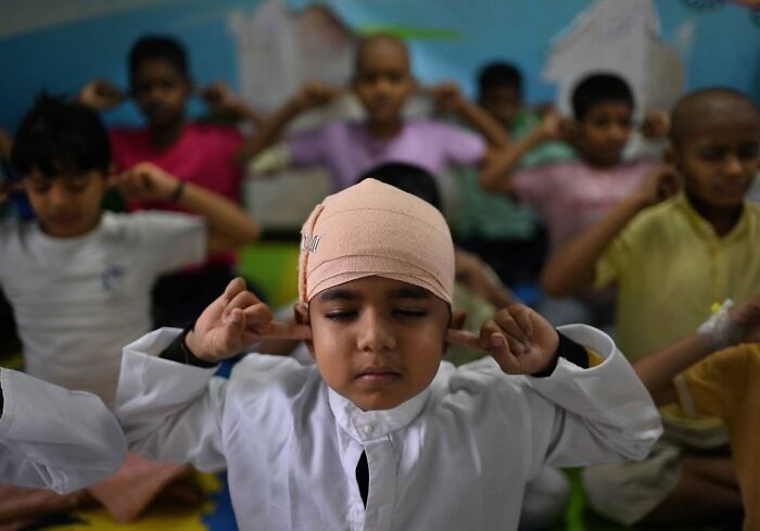 Children practicing meditation in a classroom, showcasing everyday life in Mumbai through stunning street photos.
