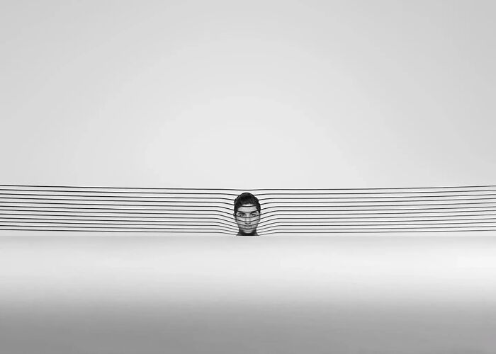 Minimalist black and white photo showing a person’s head among horizontal lines, highlighting minimalist photography art style.