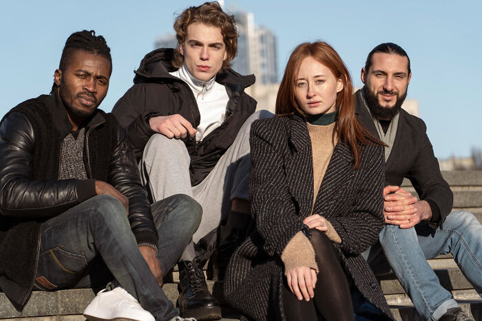 Diverse group of young adults sitting outdoors showcasing unique human body features and facts in natural light.