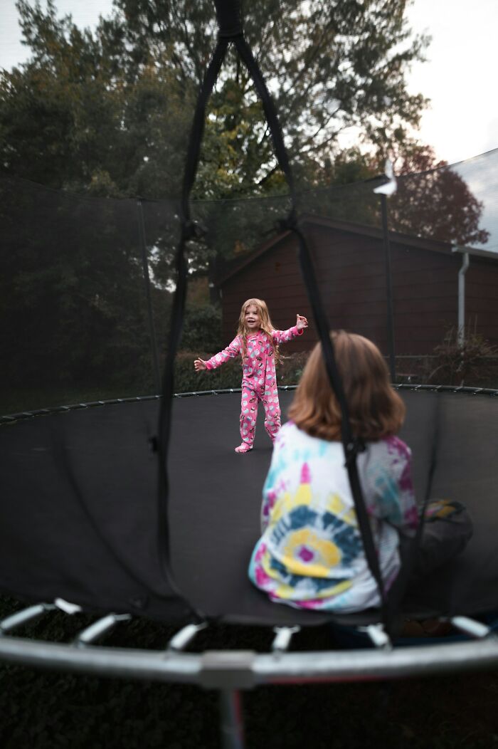 Two children playing on a trampoline outdoors, illustrating challenges ER staff face with difficult patient interactions.
