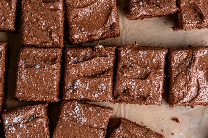 Close-up of chocolate brownies with sea salt sprinkled on top, illustrating a workplace snack in office scandal context.