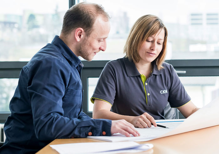 Two professionals reviewing documents together in a bright office, focusing on mental questions job candidates ask recruiters.