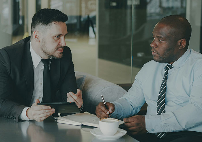Two men in business attire having a serious conversation during a job interview with mental questions asked to recruiters.