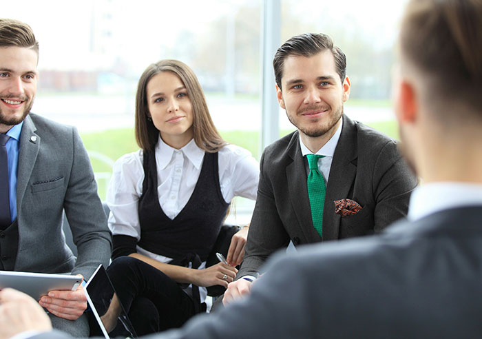 Group of recruiters in a meeting with a job candidate discussing mental questions during an interview session indoors.