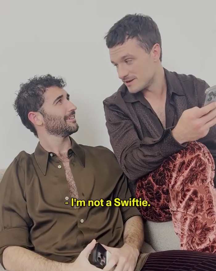 Two men engaged in conversation, with visible text saying I'm not a Swiftie, related to Josh Hutcherson comment about Taylor Swift. Two men engaged in conversation, with visible text saying I'm not a Swiftie, related to Josh Hutcherson comment about Taylor Swift.