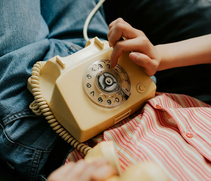 Child dialing a number on a vintage rotary phone, illustrating true stories that sound made up but actually happened.