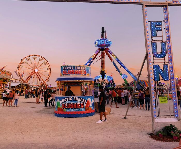 Crowd at a lively amusement park with rides and food stands capturing moments when people instinctively felt something was wrong.