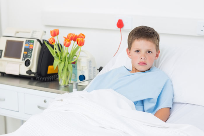 Young boy in hospital bed with medical equipment and flowers nearby, representing sacrifice and family struggle. Young boy in hospital bed with medical equipment and flowers nearby, representing sacrifice and family struggle.