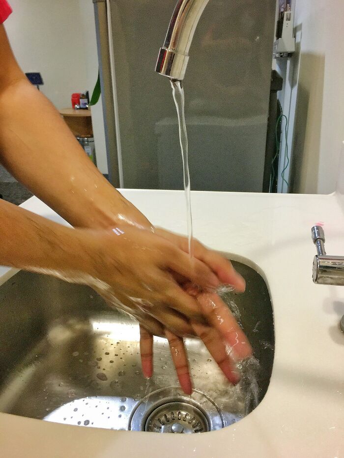 Person washing hands under running faucet in a sink, illustrating daily moments experienced while working and workplace frustrations.