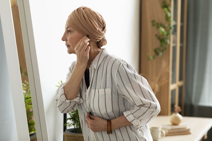 Middle-aged woman reflecting alone in front of mirror, symbolizing painful divorce and the final straw in a former friendship.