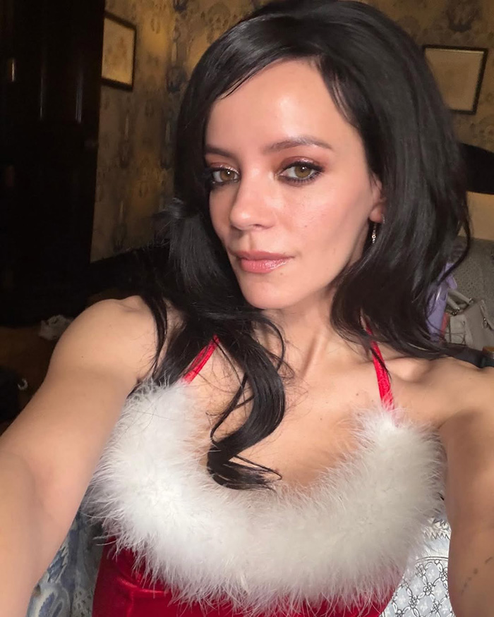 Lily Allen in a red and white dress, embracing a continual divorce celebration during her revenge era.