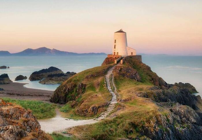 Lighthouse on a rocky hill overlooking the sea, one of the places that look AI generated but are actually real.