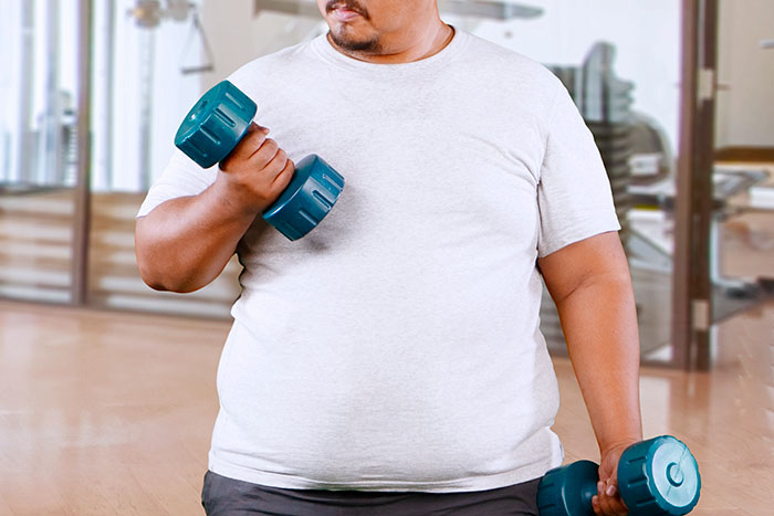 Man lifting dumbbells indoors, illustrating guy vents online about girlfriend wanting him to close her closet door.