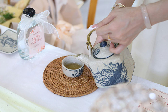 Man considers canceling wedding as fianc&eacute;e&rsquo;s family hires a private investigator to find dirt, tea ceremony setting with hands pouring tea.