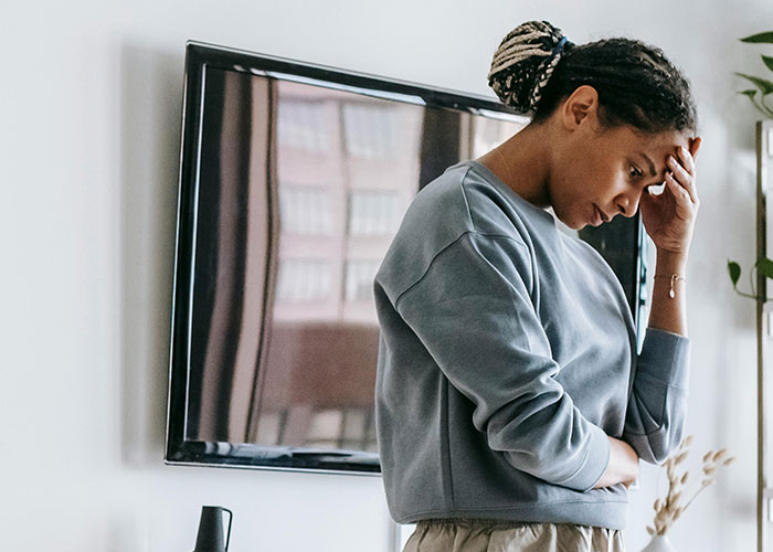 Woman looking distressed at home, illustrating phone dependence affecting family relationships and causing marital issues.