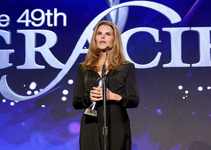 Maria Shriver speaking at a podium during an awards event, addressing topics related to Kennedy Center renaming. Maria Shriver speaking at a podium during an awards event, addressing topics related to Kennedy Center renaming.