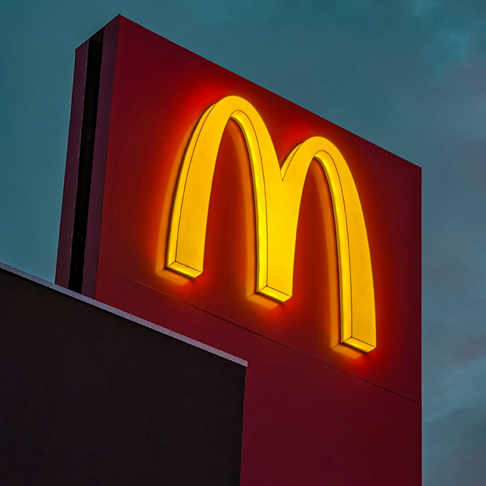 McDonald's golden arches sign illuminated against a dark evening sky, related to McRib viral video buzz. McDonald's golden arches sign illuminated against a dark evening sky, related to McRib viral video buzz.