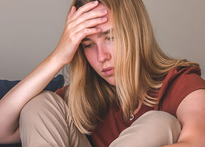 Young woman looking distressed and upset, reflecting a tense family situation involving sister and parents at Christmas.