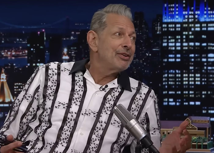 Man in a striped shirt speaking on a late-night talk show about famous people they've met and their personalities.