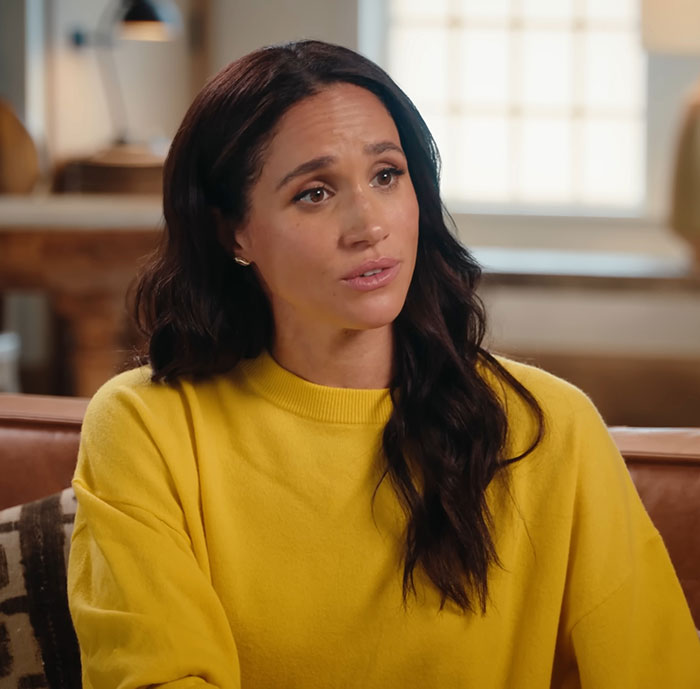 Meghan Markle seated indoors in a yellow sweater, illustrating PR gurus cutting ties with Prince Harry and Meghan Markle.
