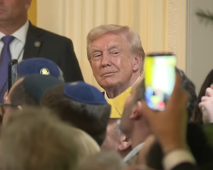 Donald Trump in a crowd, with people taking photos and capturing the moment during a public event.