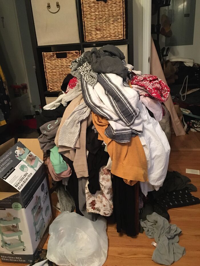 Pile of mixed clothing and household items in a cluttered room, illustrating challenges men share about women from marriage and relationships.