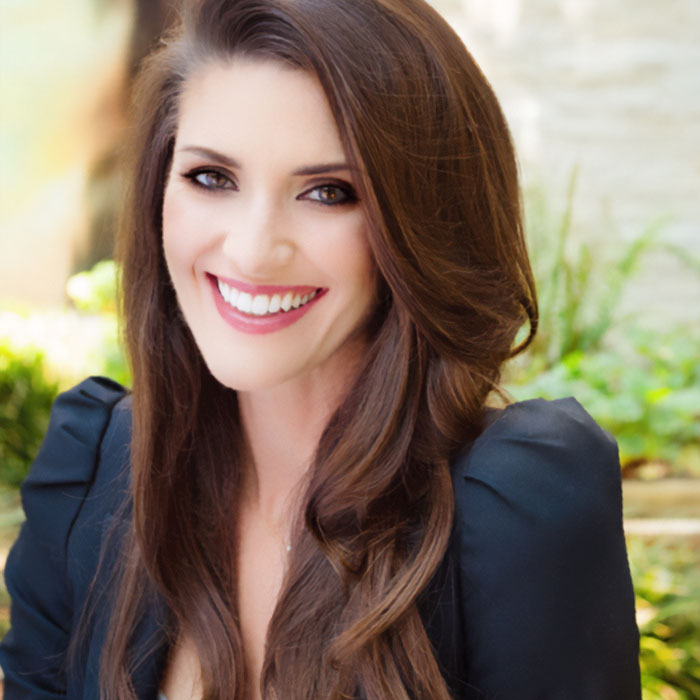 A smiling PR guru with long brown hair and a black top, discussing why they cut ties with Prince Harry and Meghan Markle.