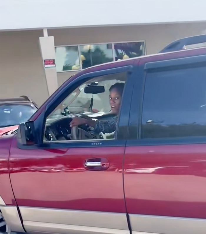 Woman sitting in red truck outside Miami gym after incident involving employee punch leading to arrest