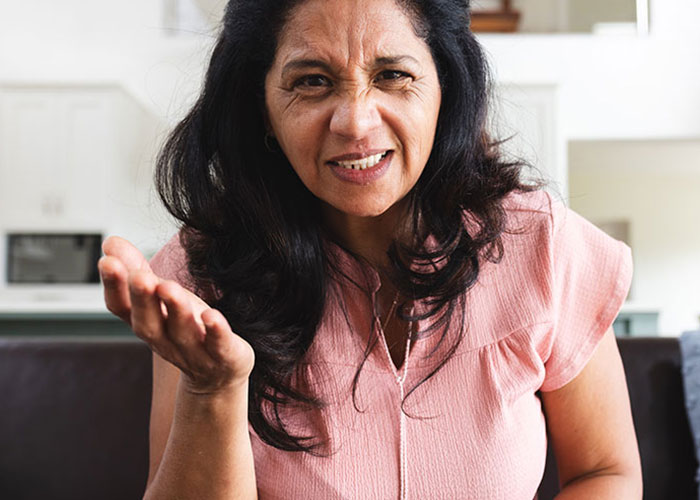Woman expressing frustration indoors, illustrating tension when reheating pizza leftovers for MIL during Christmas visit.