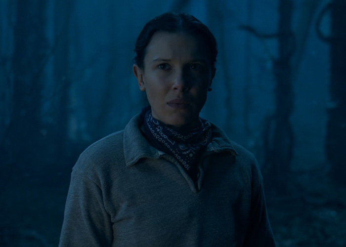 Millie Bobby Brown in a dark forest scene from Stranger Things, capturing fans' attention with a viral shot.