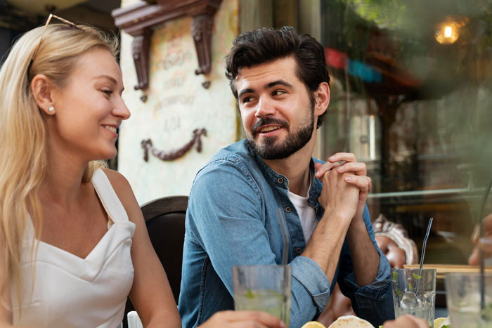 Young man and woman having a casual conversation at a restaurant, representing wedding family tensions and tantrums. Young man and woman having a casual conversation at a restaurant, representing wedding family tensions and tantrums.