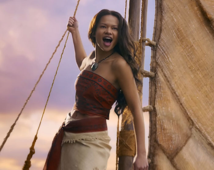 Young woman on a boat raising a rope, symbolizing Disney remakes and discussions about soulless films and racism.
