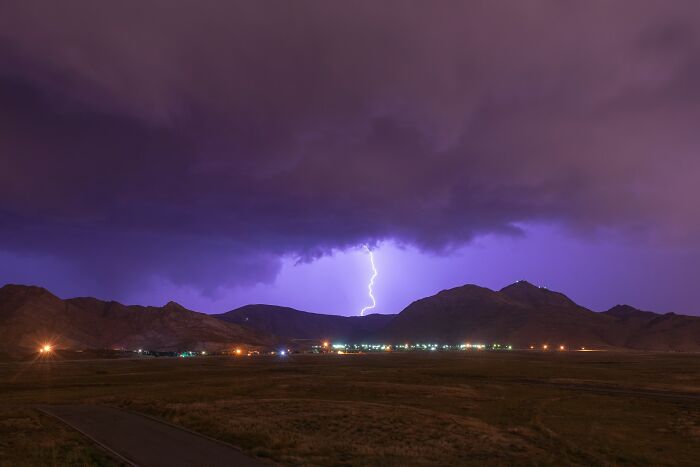 Lightning striking behind mountains at night, illustrating moments people instinctively felt something was wrong.